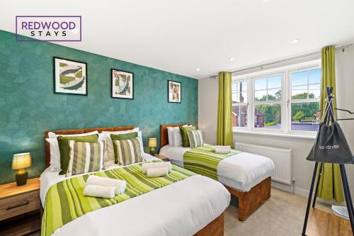 two beds in a room with green walls at Spacious 4 Bedroom 2 Bath Serviced Home For Contractors & Families with X2 Free Parking Spaces, Fast WiFi - Hosted By Redwood Stays in Farnborough