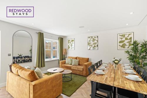 uma sala de jantar e sala de estar com uma mesa de madeira em BRAND NEW! Modern Houses For Contractors & Families with FREE PARKING, FREE WiFi & Netflix By REDWOOD STAYS em Farnborough