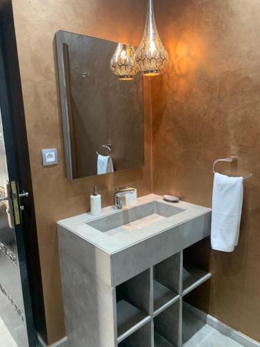 uma casa de banho com um lavatório e um espelho em RIAD LE PATIO ROMANTIQUE em Marrakech