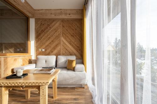 a living room with a couch and a table at Villa Tatrica in Kościelisko