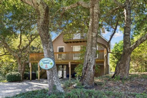 a house with a deck and a sign in front at Why Knot Getaway. Emerald Isle Oasis in Emerald Isle
