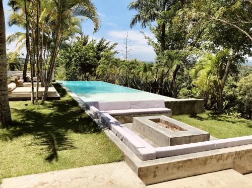 OYA - Wellness Eco Resort & Retreat في Jamao al Norte: مسبح في حديقة فيها موقد