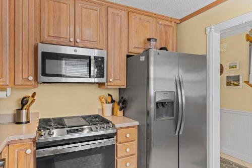 a kitchen with a stainless steel refrigerator and a microwave at Why Knot Getaway. Emerald Isle Oasis in Emerald Isle
