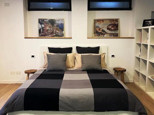 a bedroom with a black and white bed with two shelves at La Perla in Monza