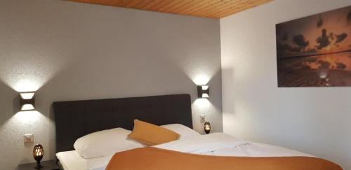 een slaapkamer met een bed met twee verlichting bij Ferienwohnung Gte rural in Courcelon