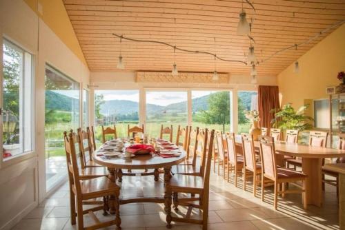 een eetkamer met een tafel en stoelen met uitzicht bij Ferienwohnung Gte rural in Courcelon