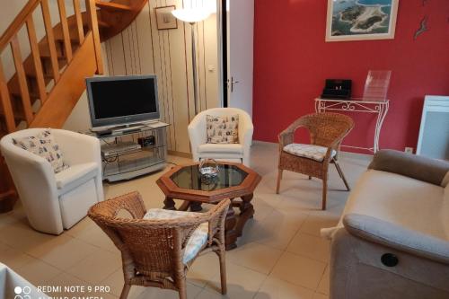 sala de estar con sillas y TV en Location classée 3 étoiles entre PerrosGuirec et P en Penvénan