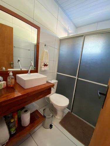 a bathroom with a toilet and a sink and a shower at Aconchego Alto da Serra in Barracão