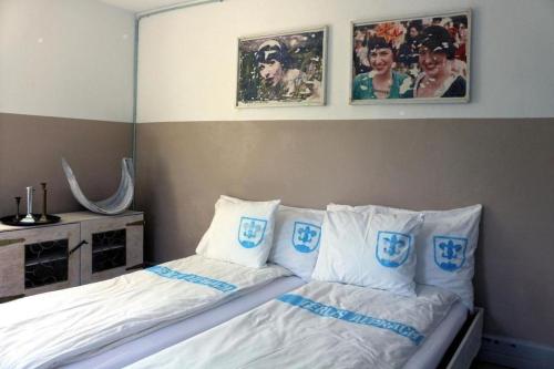 AlpnachにあるGerlis - relaxte Ferien in typischem Dorfhausのベッドルーム1室(ベッド2台付)が備わります。壁に2枚の写真が飾られています。