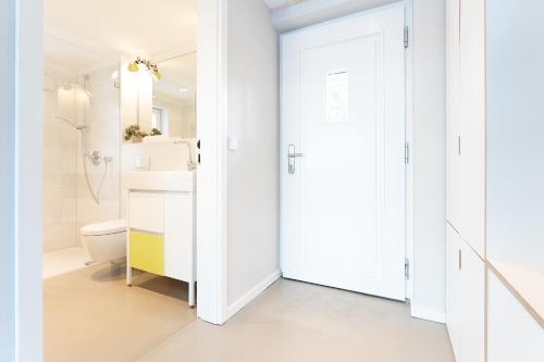 een witte badkamer met een toilet en een wastafel bij Strandhus in Travemünde