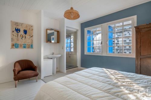 Un dormitorio con una cama y una silla y una ventana. en Belle villa bauloise à deux pas de la plage, en La Baule