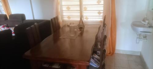 uma sala de estar com uma mesa e um lavatório em Diamond PLaza em Melinde