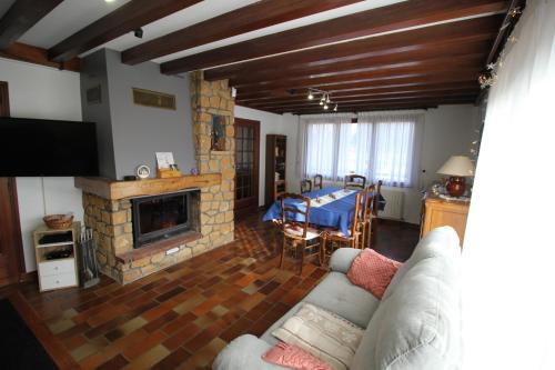 un salon avec un canapé et une cheminée dans l'établissement Chalet Les Aubarettes, au Bourg-dʼOisans