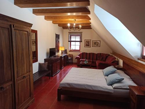 ein Schlafzimmer mit einem Bett und einem Sofa in einem Zimmer in der Unterkunft Penzion Rozmarýn in Vsetín