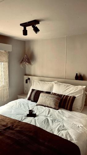 Schlafzimmer mit einem großen weißen Bett und einer Decke in der Unterkunft La Casa Di Nyo in Sevenum