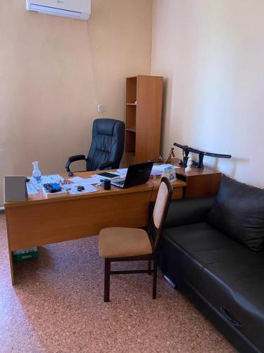 a office with a desk with a gun on a couch at Фермерское хозяйство in Karagandy