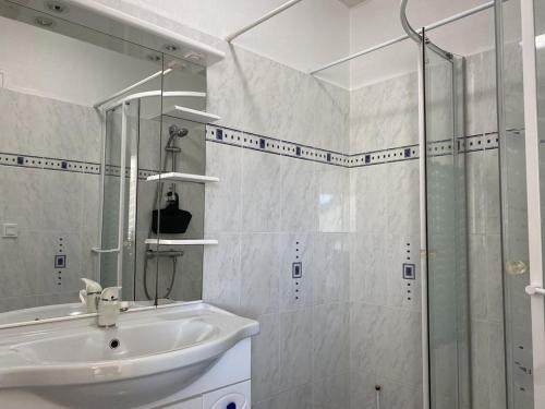 une salle de bain avec un lavabo et une douche en verre dans l'établissement 606 - Appartement à Erquy, à 700m de la plage et des commerces, à Erquy