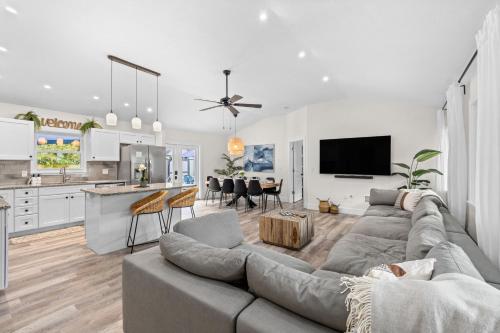 a living room with a gray couch and a kitchen at Heated Salt Pool, Arcade, 2 Kings, Near Ami, Img in Bradenton