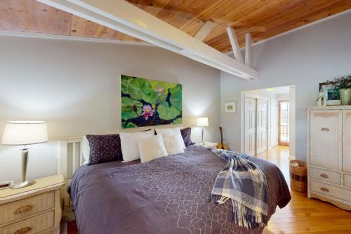 a bedroom with a bed with a purple comforter at Awesome Views in Cambria