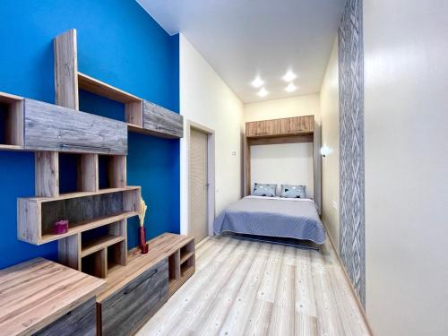 1 dormitorio con cama y pared azul en Sumskaya street, en Járkov