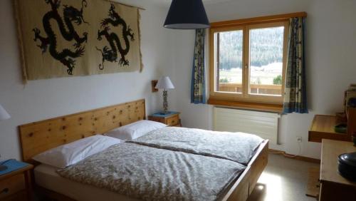 Schlafzimmer mit einem Bett und einem Fenster in der Unterkunft Chesa Azalea 14 in Pontresina
