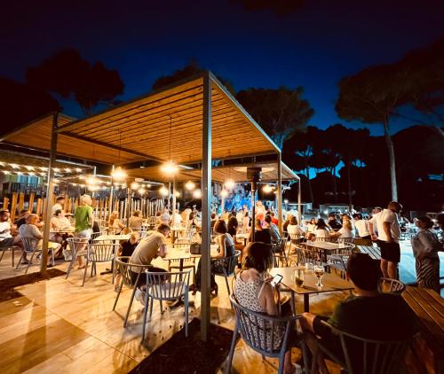 a group of people sitting at tables at a restaurant at Interpals Eco Resort in Pals