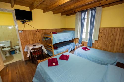 - une chambre avec 2 lits avec des archets rouges dans l'établissement Alma Alquimia, à Valle Hermoso