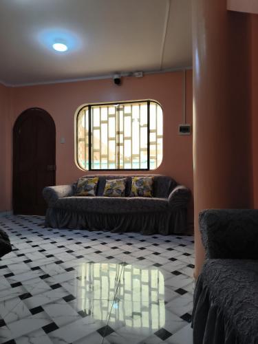 ein Wohnzimmer mit einem Sofa und einem Glastisch in der Unterkunft Hostal Venecia in Caral