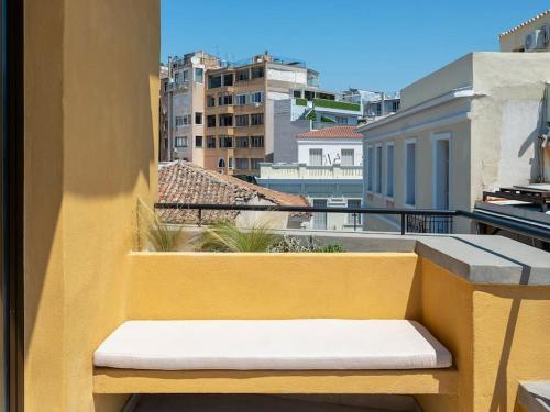 un banco amarillo sentado en la parte superior de un balcón en Hoppersgr- Amazing apt in the heart of Athens - 6 en Athens