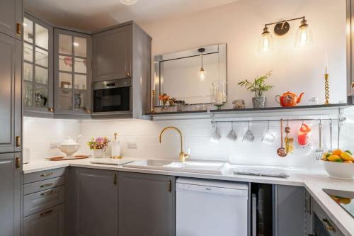 a kitchen with gray cabinets and a sink at Bijou apartment in the heart of Melrose in Melrose