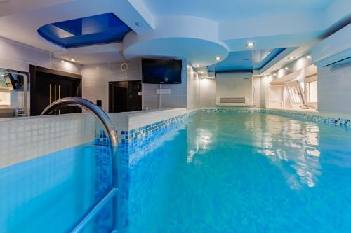 a large swimming pool with a blue ceiling at Luxury Apartment with Pool and Hammam in Kyiv