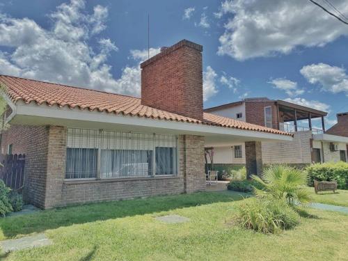 a house with a brick chimney on top of it at Chalet tradicional a metros de la playa in Piriápolis