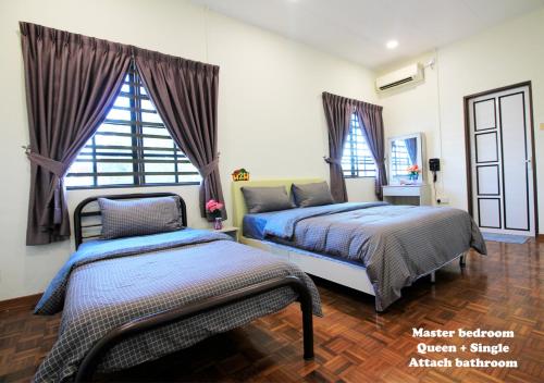a bedroom with two beds and a window at H2H - Bintang49 Vacation House in Ipoh