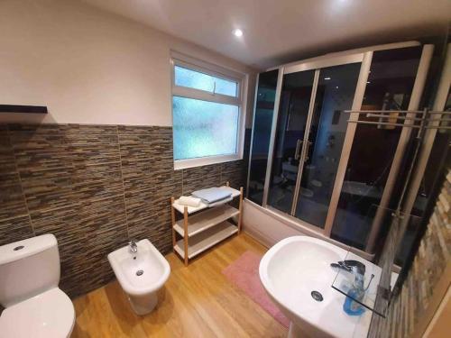 een badkamer met een toilet, een wastafel en een raam bij Amazing flat in the middle of the golf course in Manchester