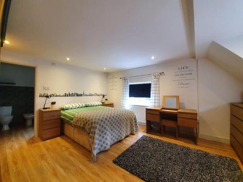 een slaapkamer met een bed, een bureau en een raam bij Amazing flat in the middle of the golf course in Manchester