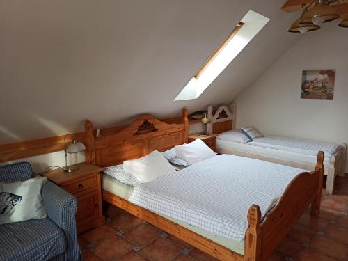 a bedroom with two twin beds and a chair at Penzion Rozmarýn in Vsetín