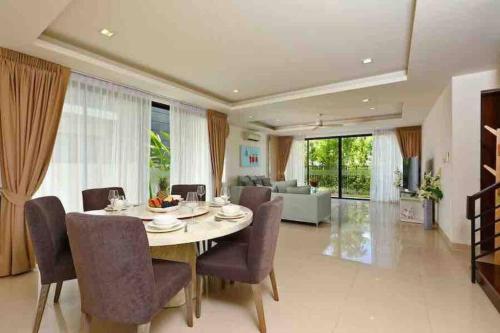 a dining room with a table and chairs and a living room at Big Lucky home in Laguna park in Bang Tao Beach