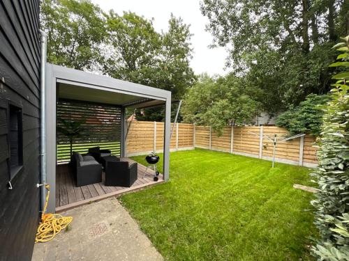 a backyard with a covered patio with a green lawn at Appartement cosy à louer in Berck-sur-Mer