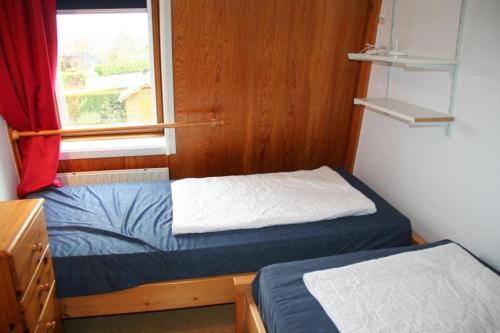 a small room with two beds and a window at Heggerank 66* in Nieuwvliet