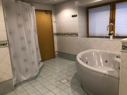 a bathroom with a tub and a shower curtain at Riia Villa in Tartu