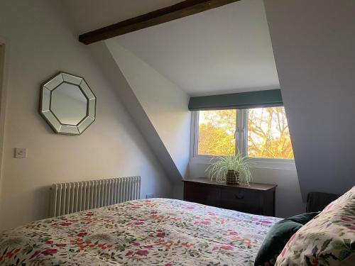 歐弗斯特蘭德的住宿－Mill Cottage Overstrand，一间卧室配有一张床、镜子和窗户