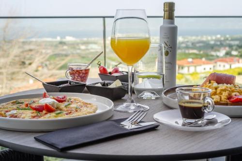 Kórinthos的住宿－ACRO Upscale Residences，一张桌子,上面放着一盘食物和一杯葡萄酒