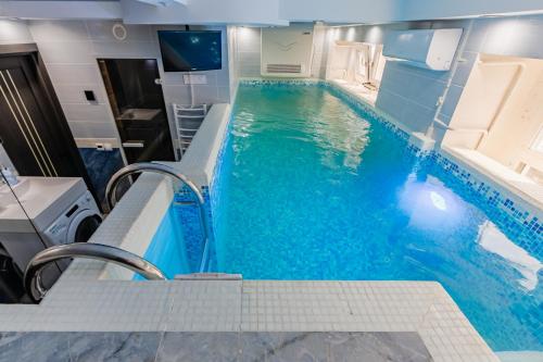 a swimming pool with blue water in a hotel room at Luxury Apartment with Pool and Hammam in Kyiv