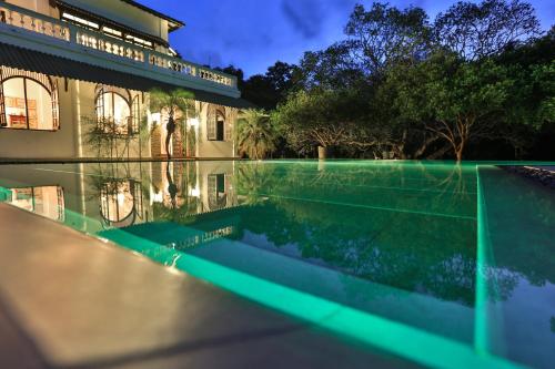 a house with a swimming pool at night at Horathapola Estate in Marawila