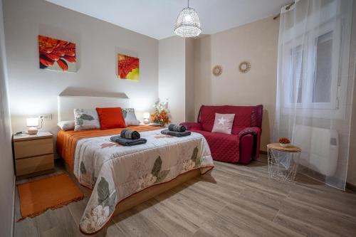 een slaapkamer met een bed en een rode bank bij Lembranzas in Padrón