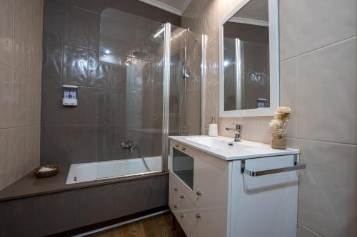 a bathroom with a sink and a shower and a tub at Lembranzas in Padrón