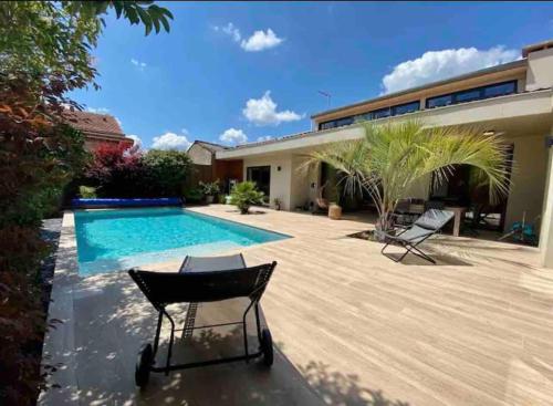 une cour arrière avec une piscine et une maison dans l'établissement Maison d architecte Bruges/piscine chauffée/Tram D, à Bruges