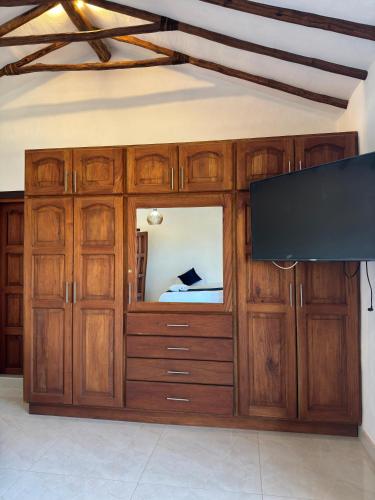 a large wooden entertainment center with a flat screen tv at Hotel Palais Barichara in Barichara