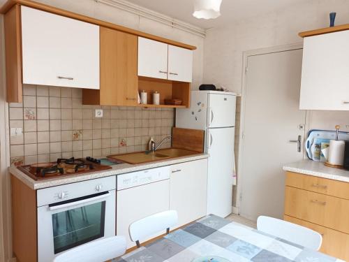 une cuisine avec des armoires blanches et un réfrigérateur blanc dans l'établissement 654 - Charmante maison à Erquy, à environ 1km200 du centre des commerces et des plages, à Erquy