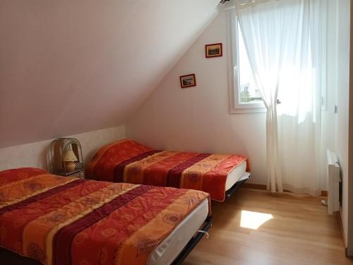 Cette chambre comprend 2 lits et une fenêtre. dans l'établissement 654 - Charmante maison à Erquy, à environ 1km200 du centre des commerces et des plages, à Erquy